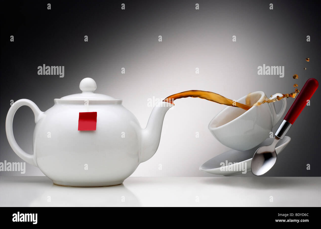 Tea, white porcelain, crockery, tea pot, floating cup, pouring tea, spilling tea, tea spout, tea bag, spoon, teaspoon Stock Photo