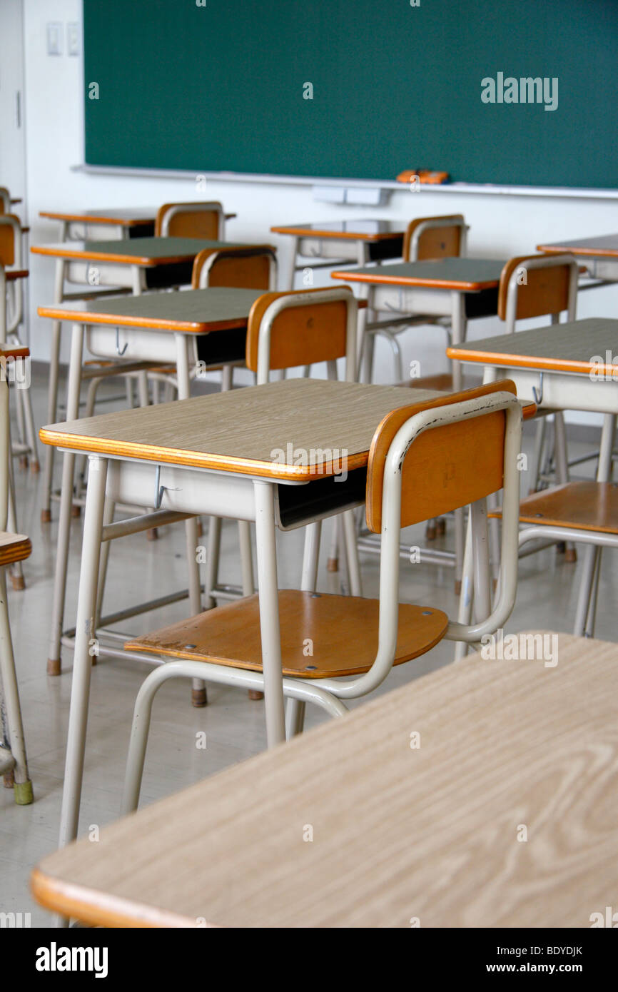 Empty classroom. Only school desks, chairs and a blackboard. No students. Stock Photo