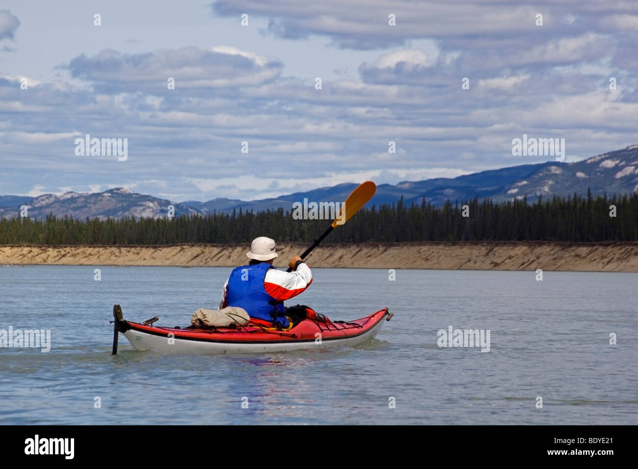 Man paddling a sea kayak on Yukon River near Lake Laberge, Yukon