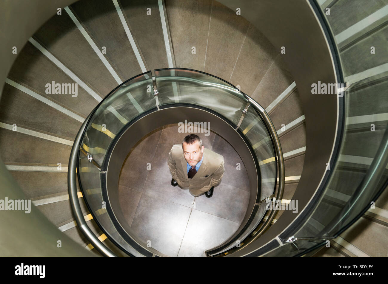 Business man at bottom of spiral stairs Stock Photo