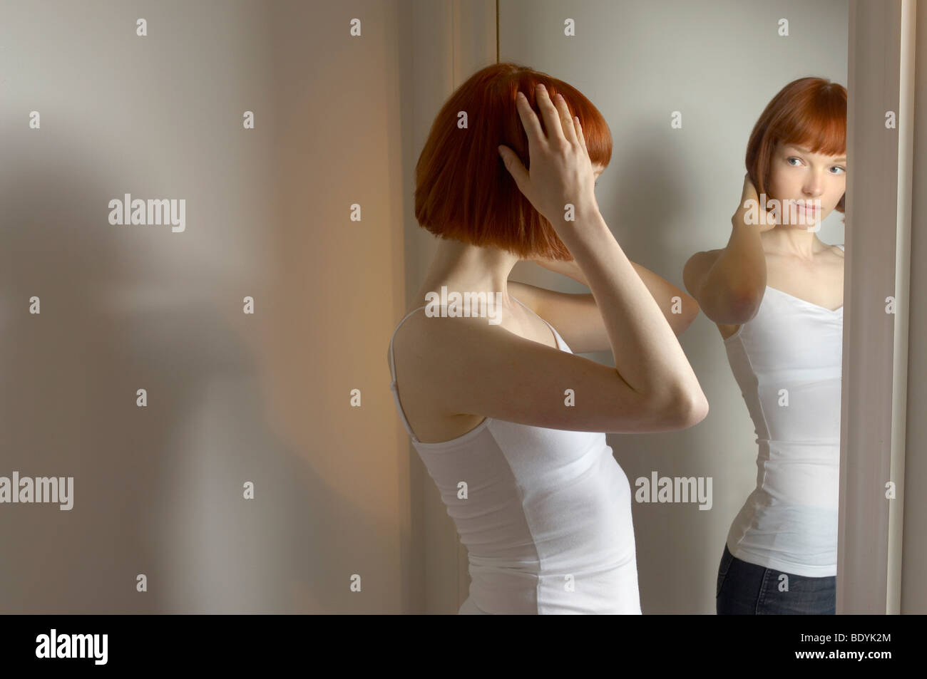 woman looking at reflection in mirror Stock Photo