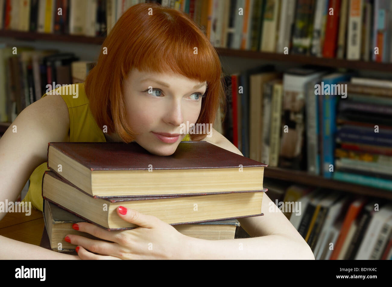 woman leaning on pile of books Stock Photo - Alamy