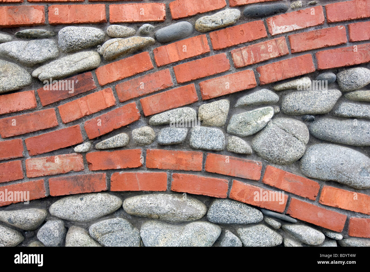 Brick and rock wall with fuchsia plant. Bandon Oregon Stock Photo