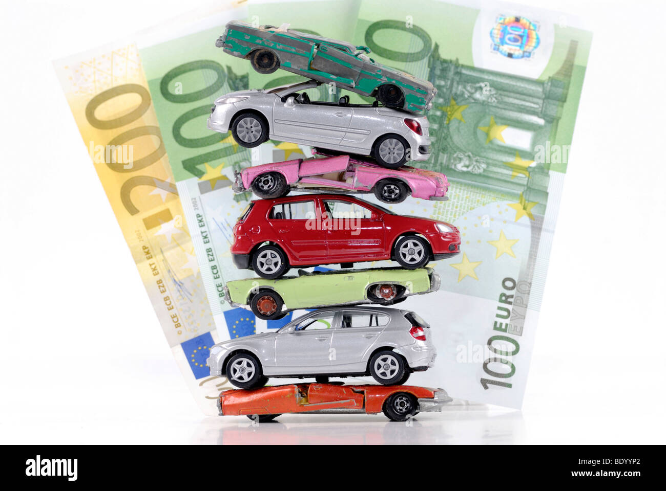 Stack of damaged and new miniature cars, a symbolic image for the faltering sale of new vehicles after the end of the scrapping Stock Photo