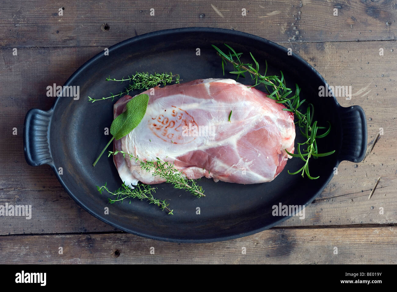 Lamb shoulder with a labelling stamp and spices sage, thyme, rosemary Stock Photo