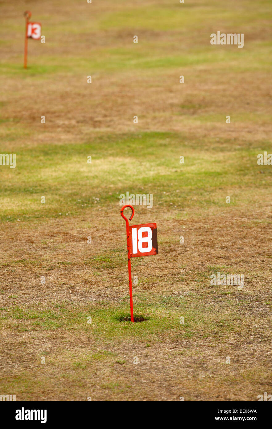 The eighteenth hole on a putting green, the thirteenth in the background. Stock Photo