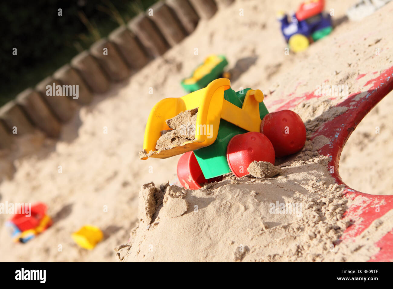 Childrens toys in a sand pit play area Stock Photo