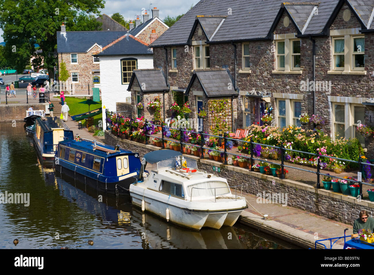 Terrace of canalside cottages of traditional design with floral displays outside in Brecon Powys Wales UK Stock Photo