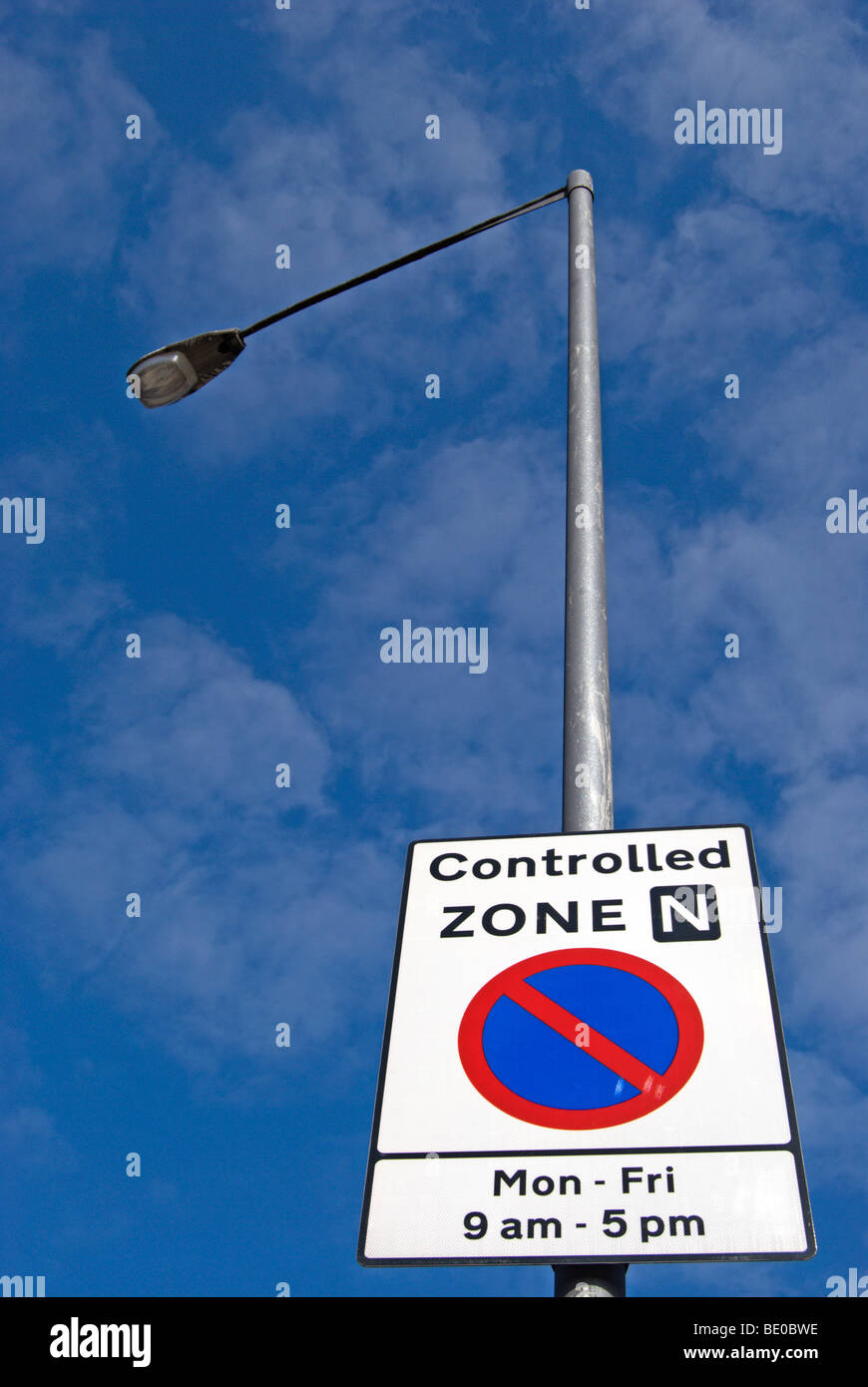 british road sign indicating controlled parking zone, with no waiting symbol and hours of operation Stock Photo