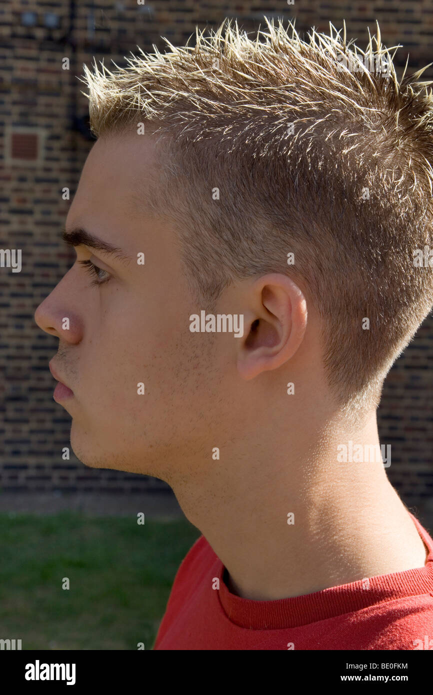 Close up profile of young man with short, spikey and highlighted hair Stock Photo