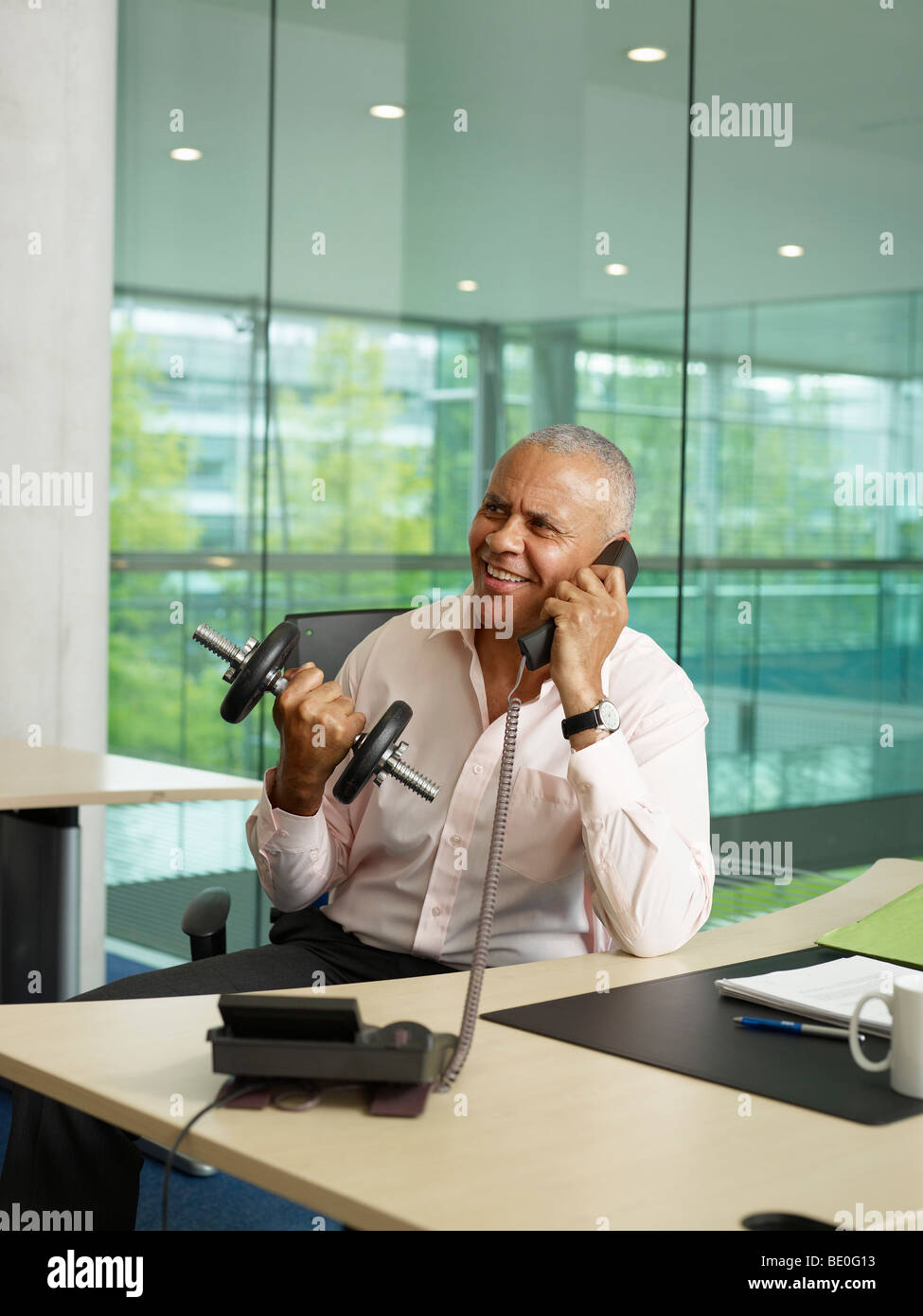 A man exercises while on the phone Stock Photo