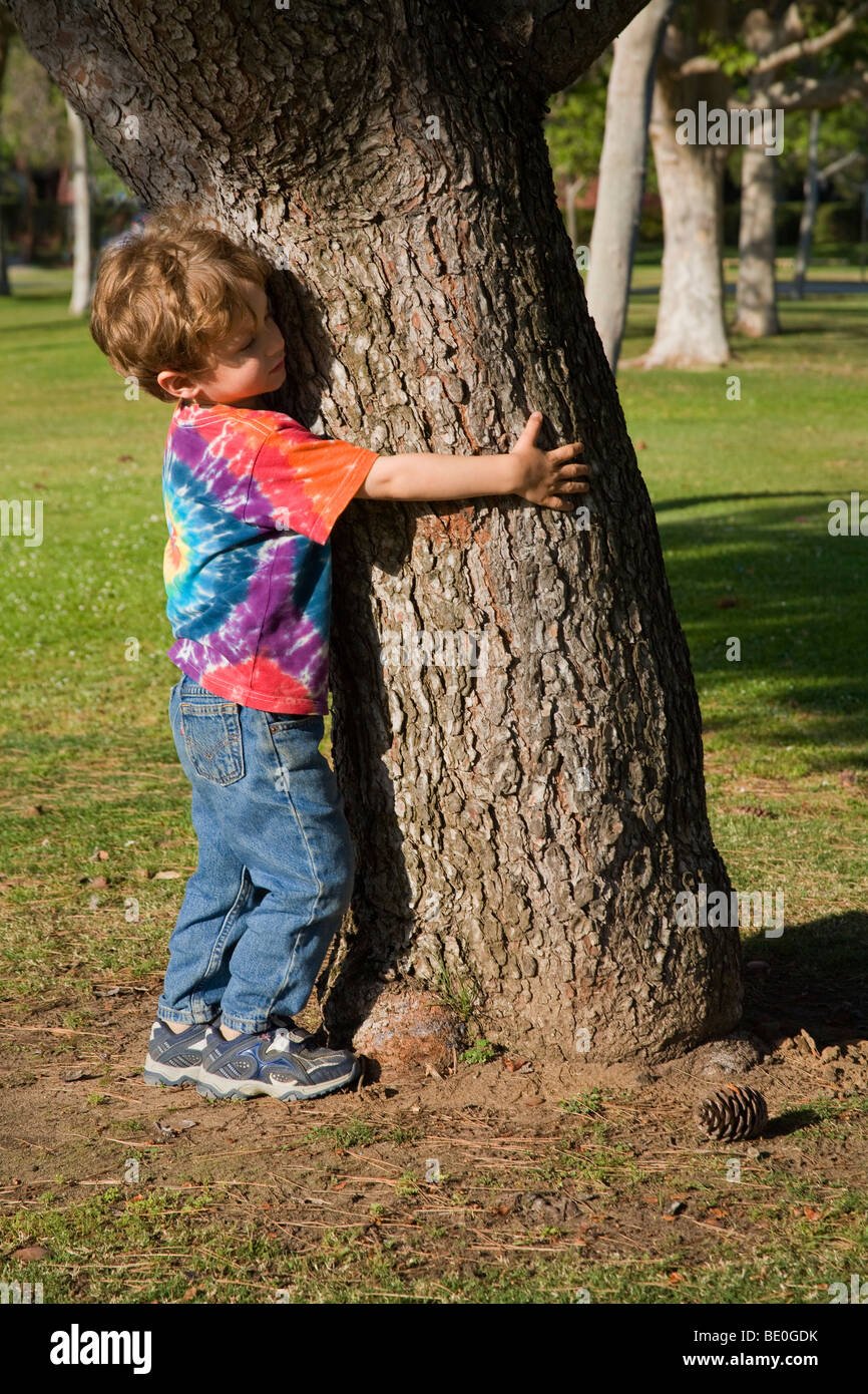 Young boy hugging tree. (MR) Stock Photo