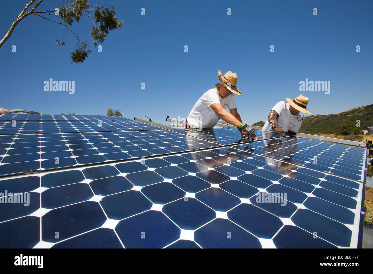 Workers install a solar array on a hillside in Malibu, California, USA ...