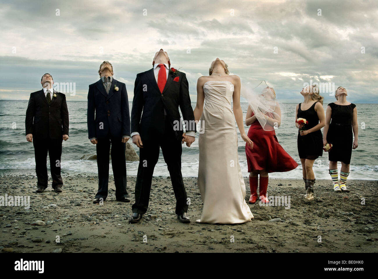 Wedding party on beach under threatening storm clouds Stock Photo