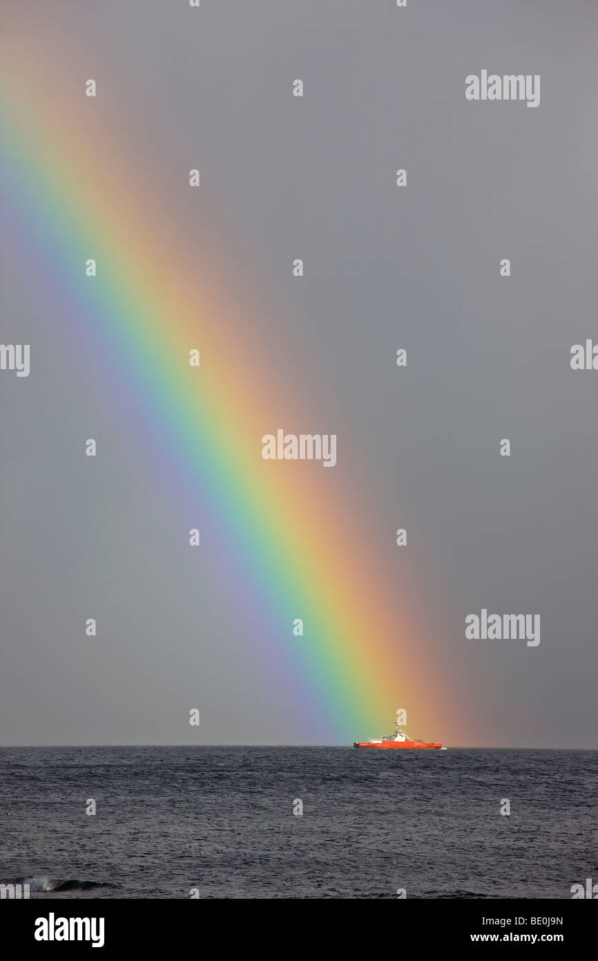 Dunoon, Argyll, Scotland; Rainbow leading to a boat on the ocean Stock ...