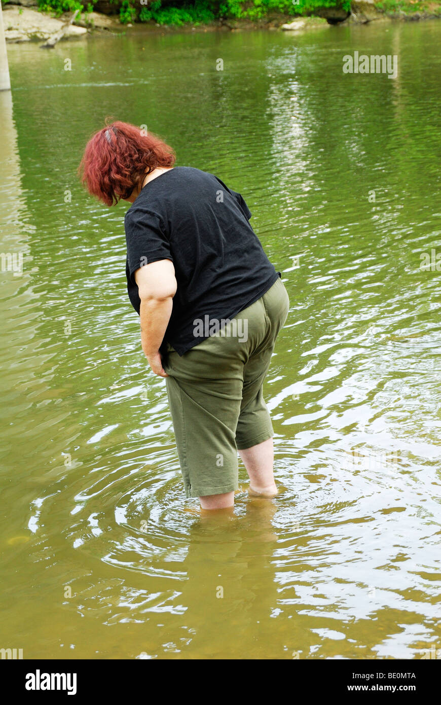 woman wading in the licking river in Zanesville ohio Stock Photo