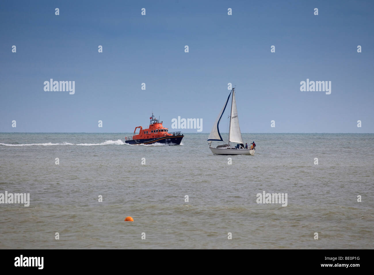 A lifeboat passing a yacht close to St Margaret's bay, Kent Stock Photo