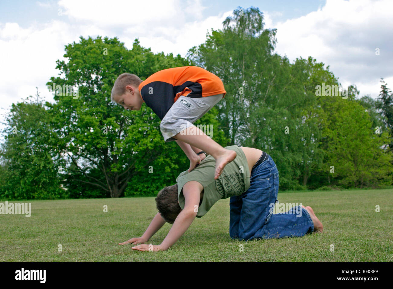 two young boys playing leapfrog Stock Photo