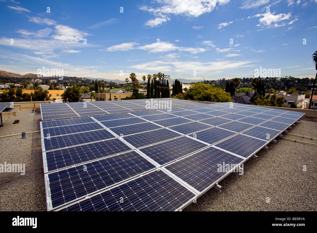 Solar array on rooftop of Asian Pacific Health Care offices with Hollywood Hills in background, Los Angeles, California, USA Stock Photo