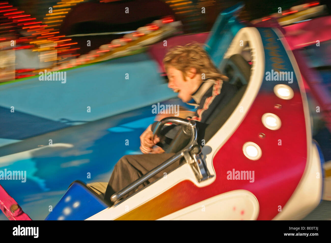 a young boy going on a ride at a carnival Stock Photo - Alamy