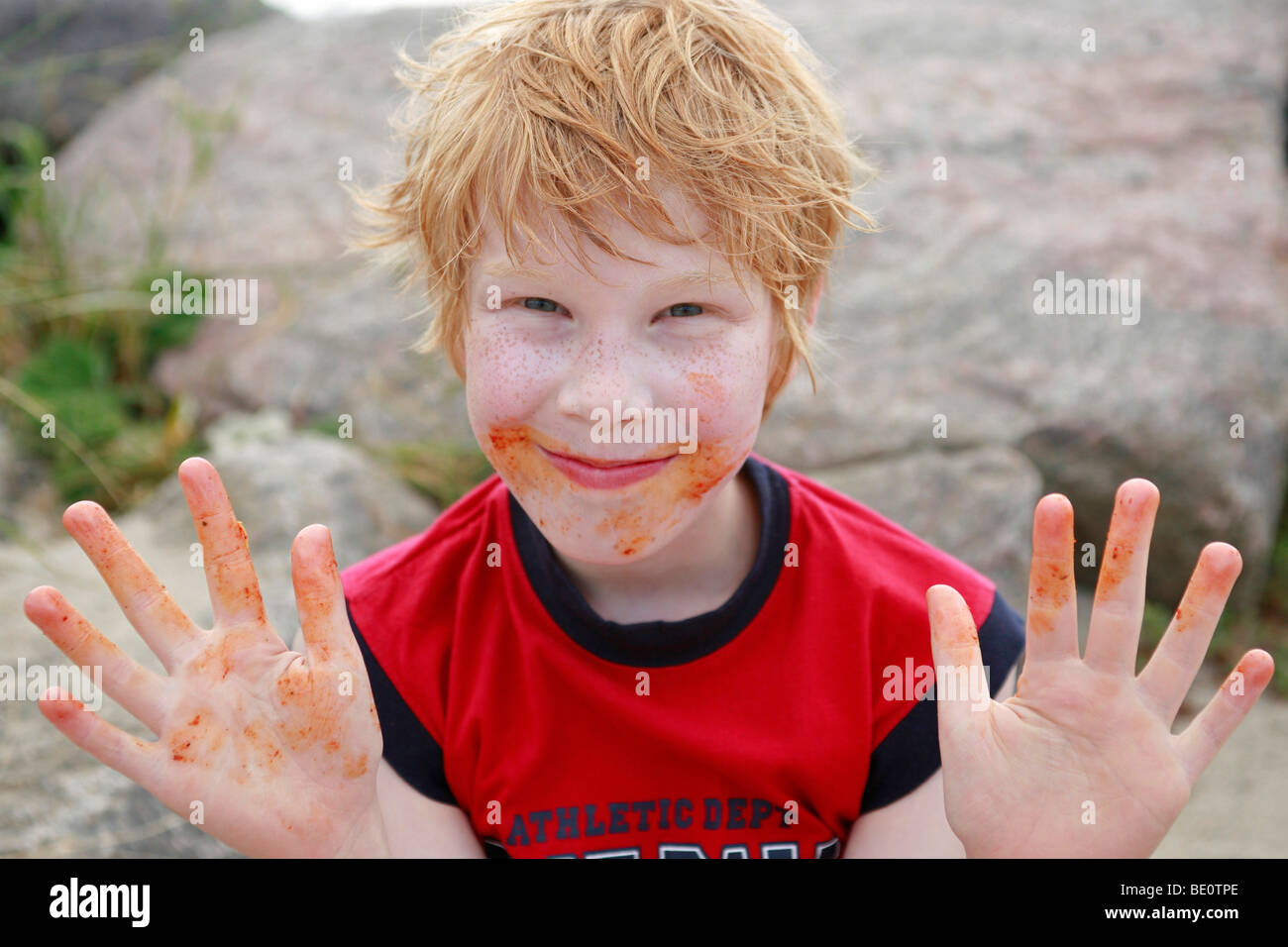 portrait of a young boy showing his dirty hands after eating Stock Photo