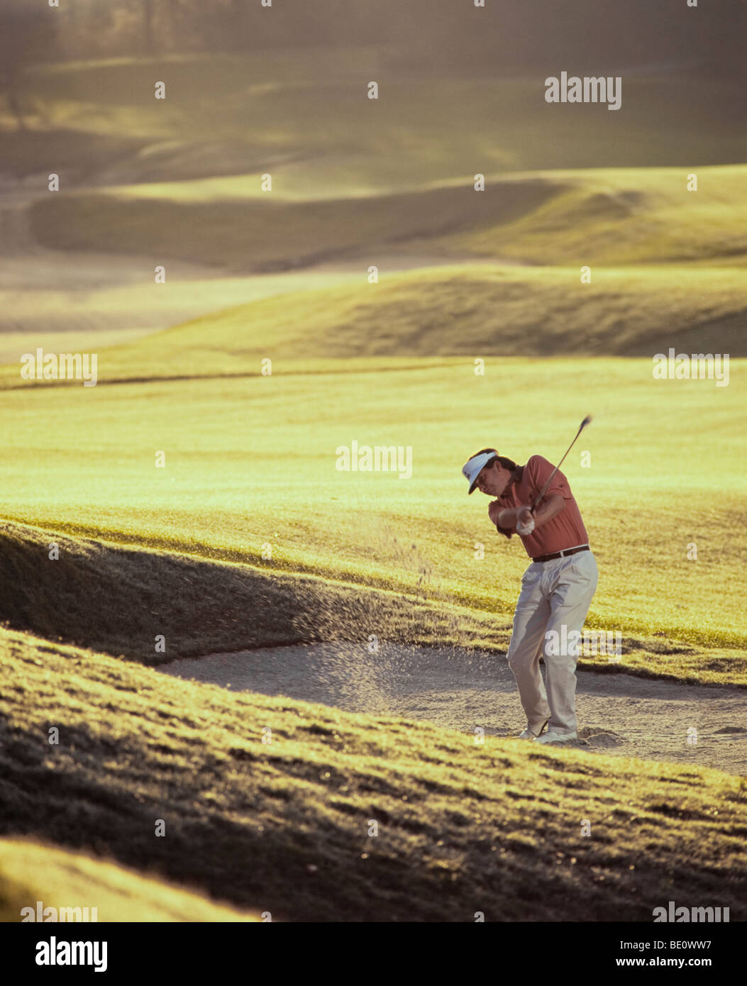 Man golfer chipping from sand trap Stock Photo