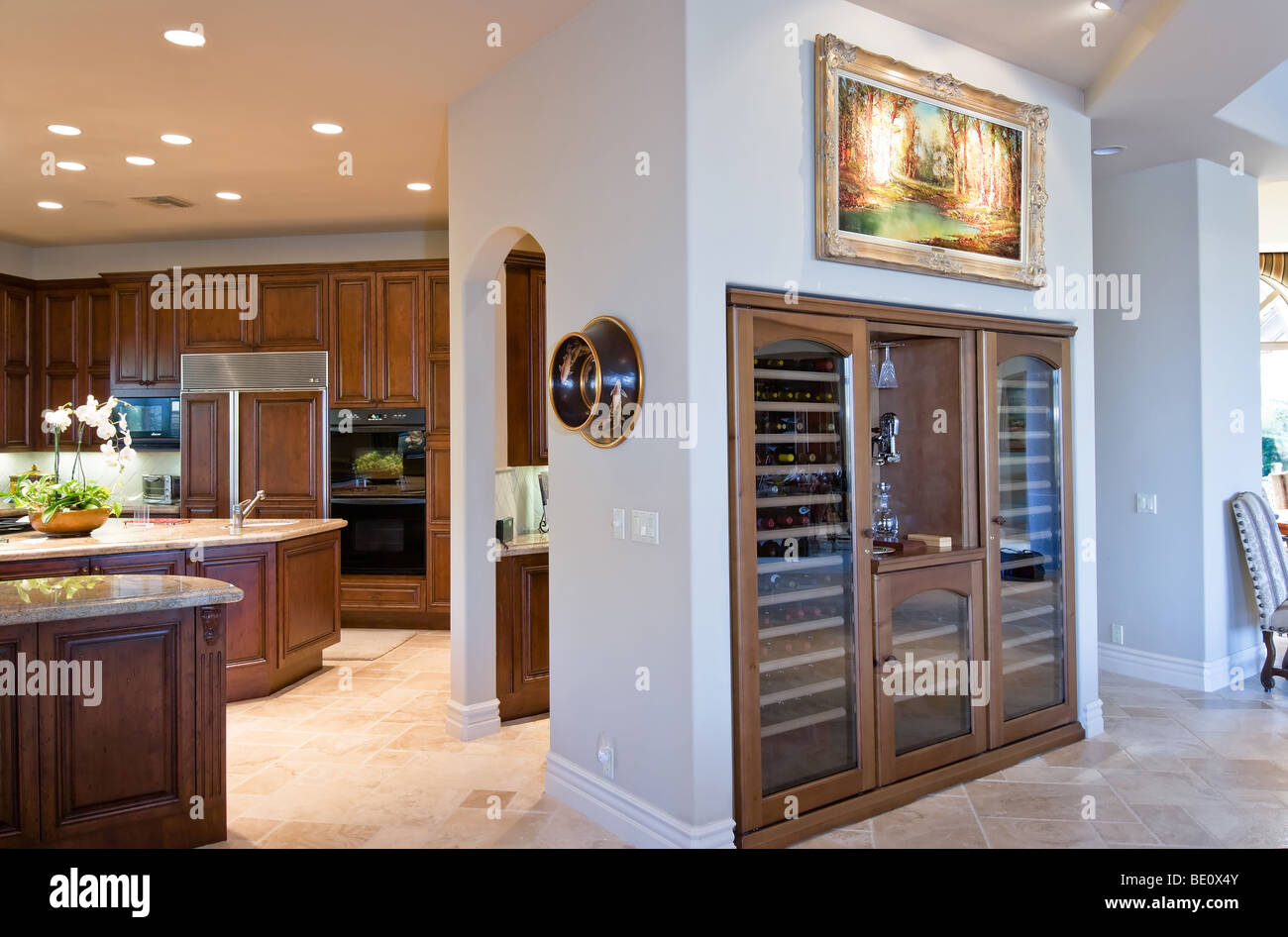 Side view of built-in wine bar adjacent to modern kitchen with dark wood cabinets Stock Photo