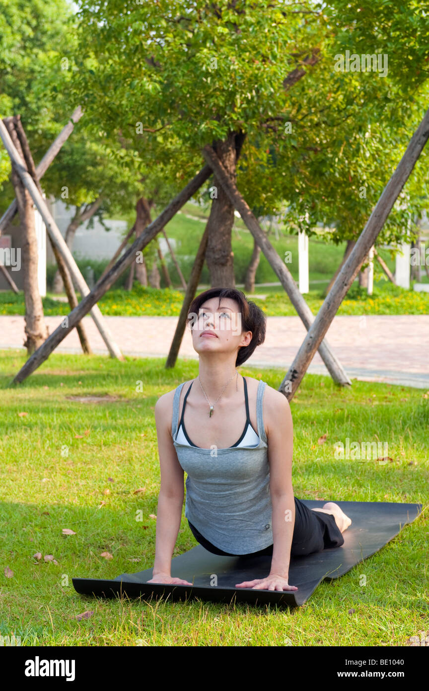 Woman Doing Yoga Outdoors In Park Stock Photo
