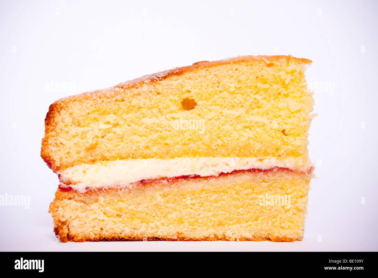 A close up of a slice of victoria sponge cake on a white background Stock Photo