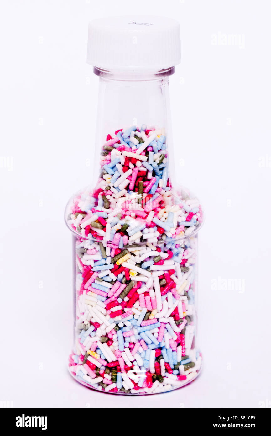 A close up of a jar of coloured hundreds and thousands cake decorations on a white background Stock Photo