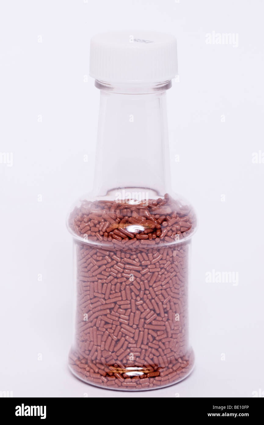 A close up of a jar of chocolate hundreds and thousands cake decorations on a white background Stock Photo