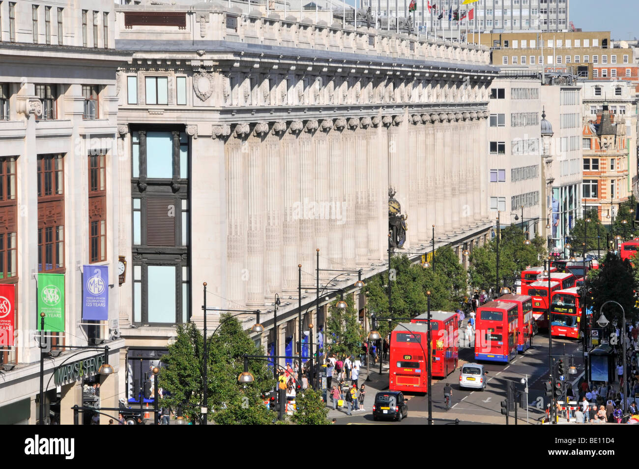 Oxford Street frontage of Selfridges department store with queue of double decker red London buses West End London England UK Stock Photo