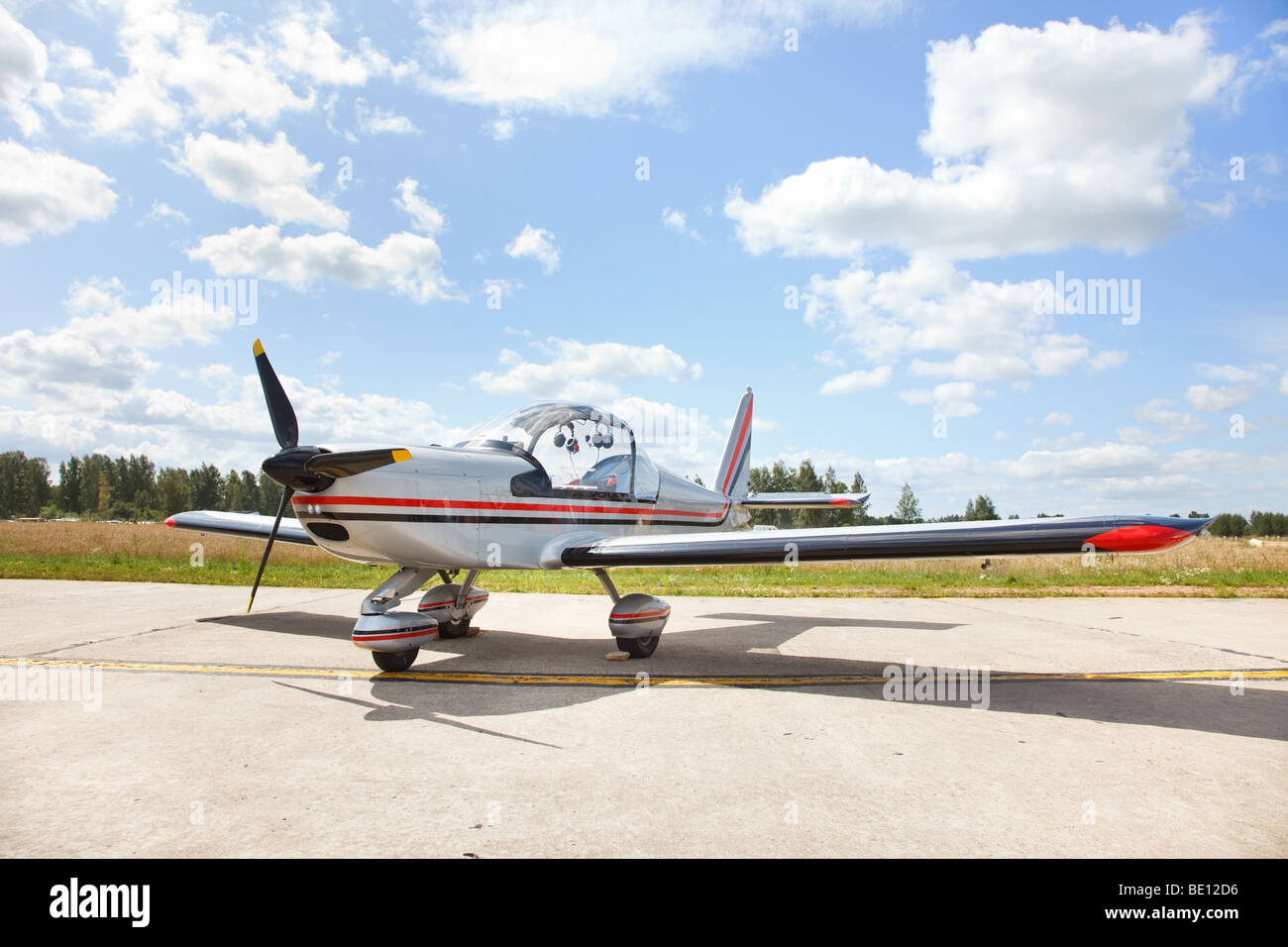 Small lightweight private airplane standing on landing strip in airfield Stock Photo