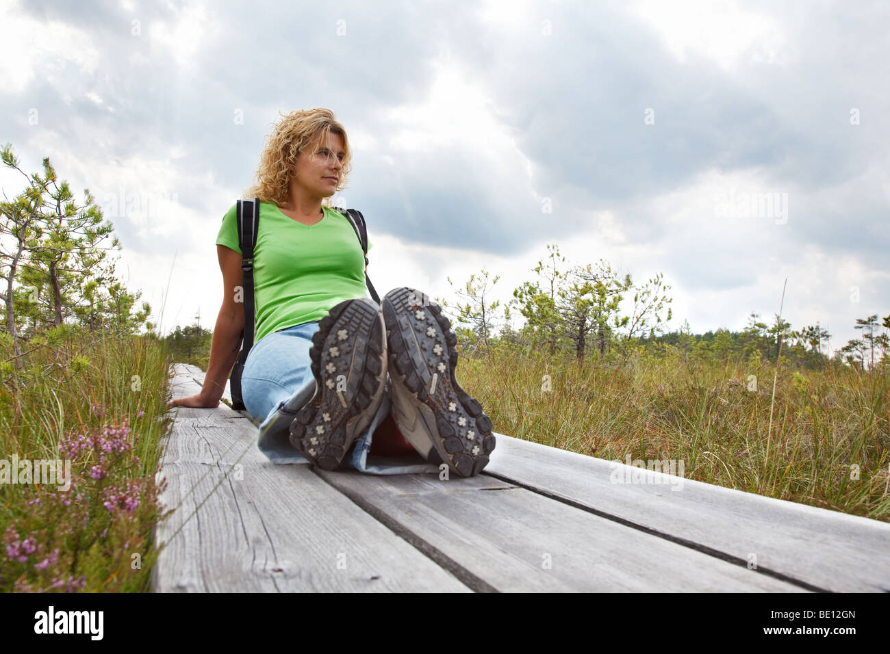 Woman resting after a walk, sitting on plankway Stock Photo