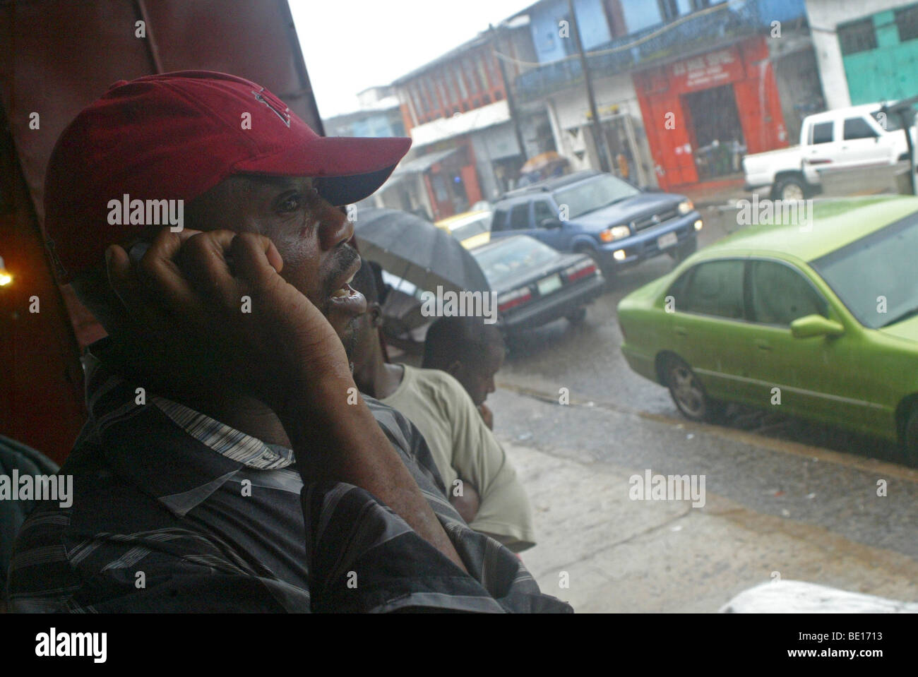 Monrovia, Liberia - September , 3, 2008: A man(Muj Attia) making a phone call from a street corner downtown Monrovia Photo by , Stock Photo