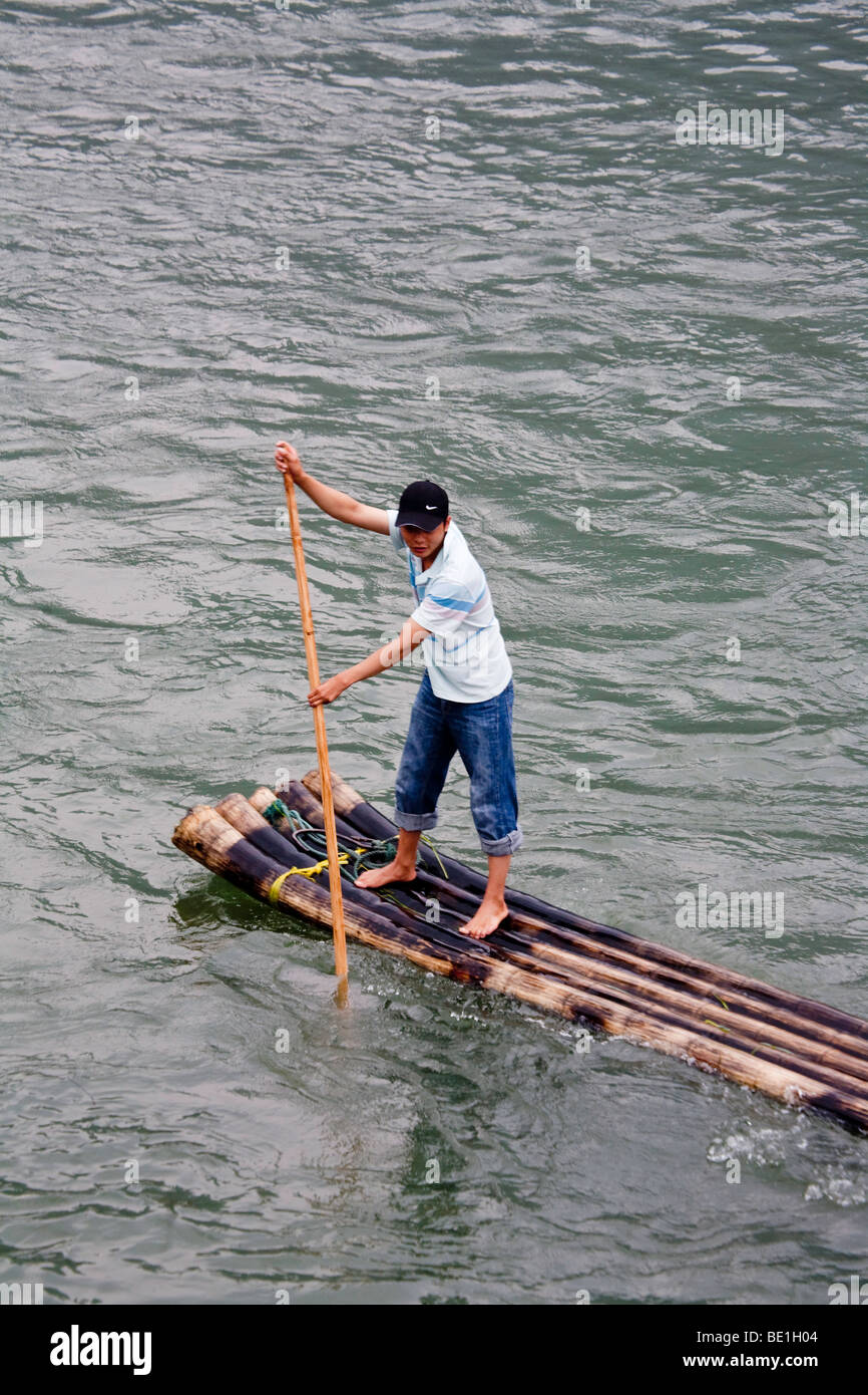 young chinese  man paddling on the Li river on a bamboo raft Stock Photo