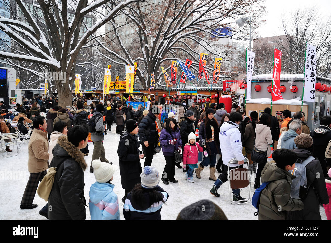 Food stands and visitors at the Sapporo Snow Festival Stock Photo