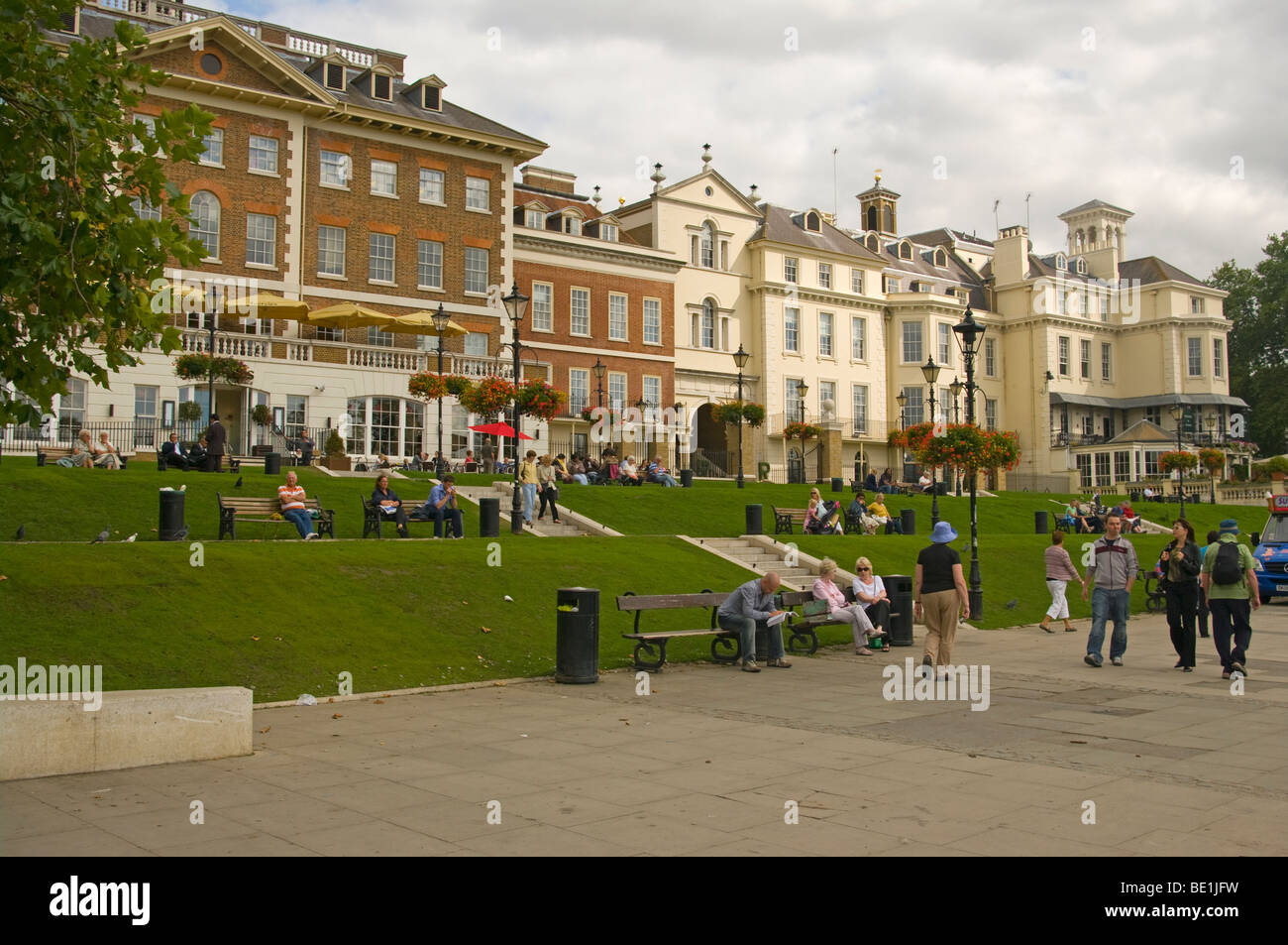 People Enjoying A Summers Afternoon On A Grass Terrace Overlooking The River Thames Richmond Surrey England Stock Photo