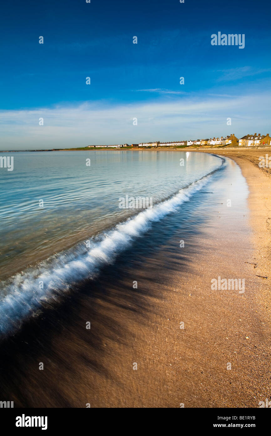 England, Northumberland, Newbiggin by the sea. Coal dust revealed by a retreating wave on the Newbiggin by the sea beach. Stock Photo