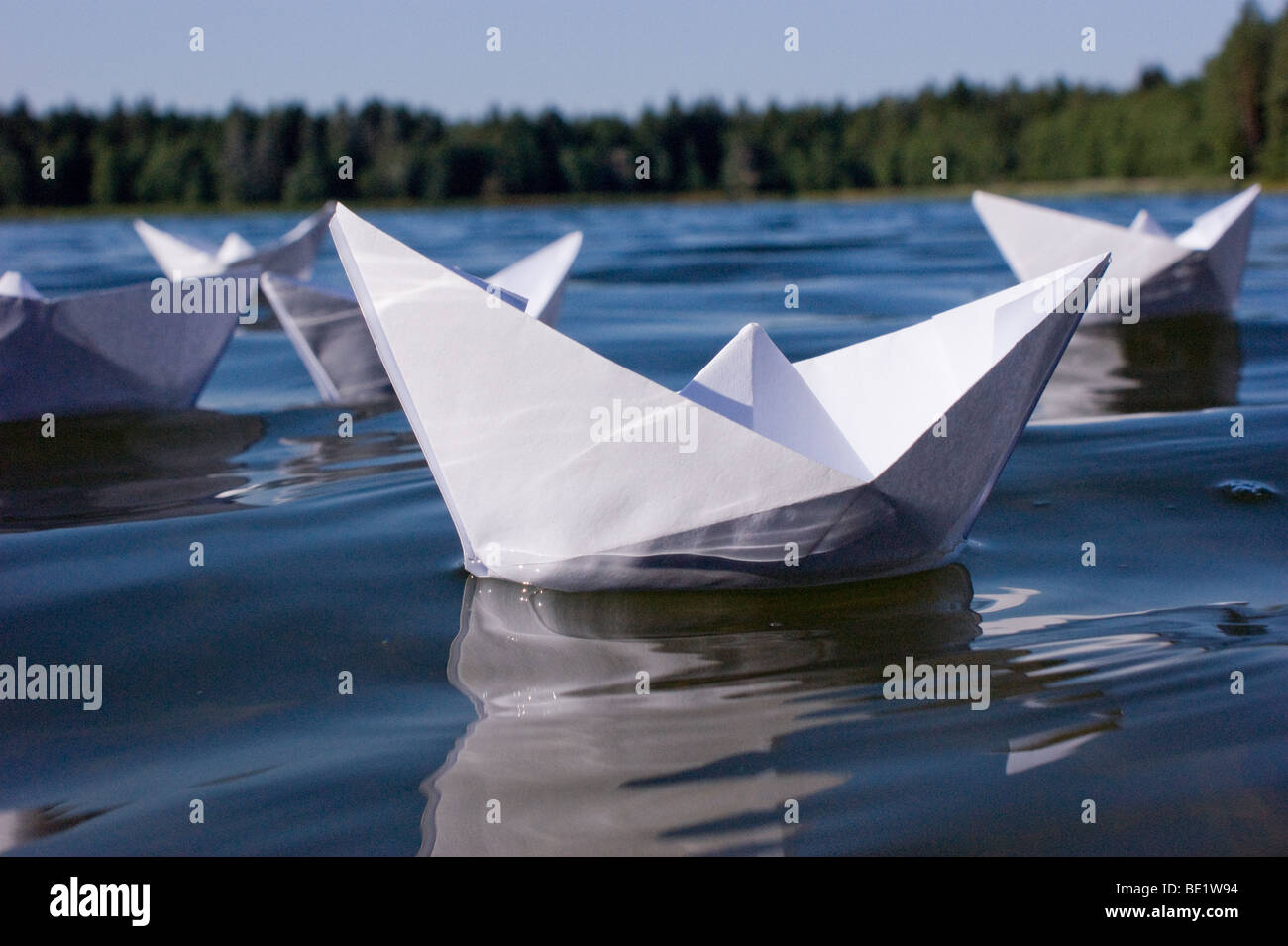 fleet of handmade paper boats (origami) in lake Stock Photo