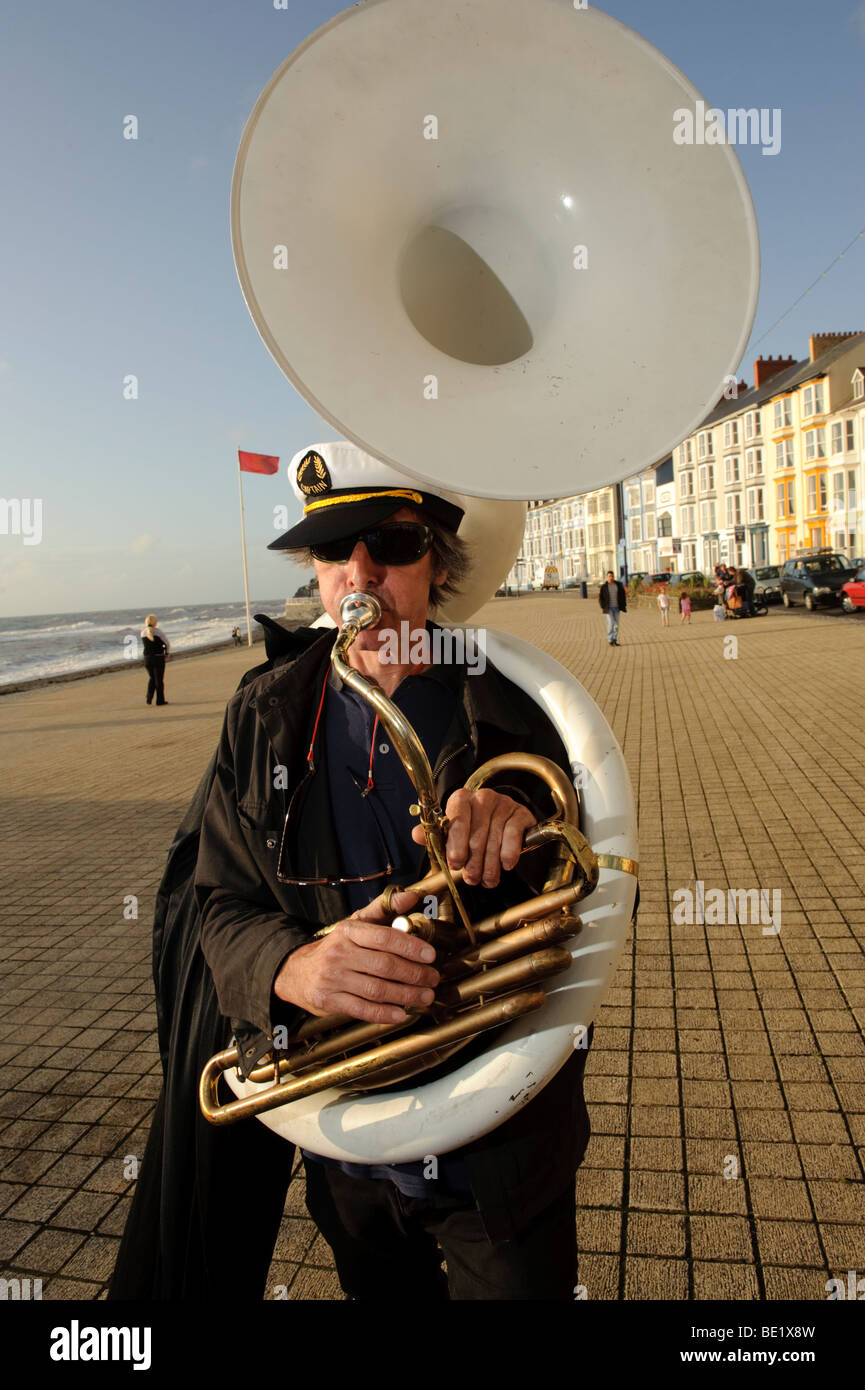 Musician playing white sousaphone the De Propere Fanfare belgian marching band performing on the promenade, Aberystwyth Wales UK Stock Photo