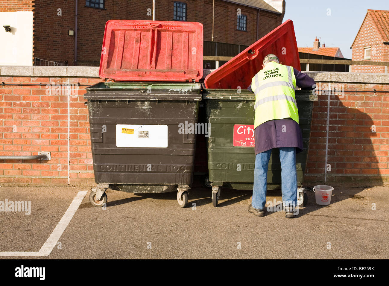 rubbish collector at bin Stock Photo Alamy