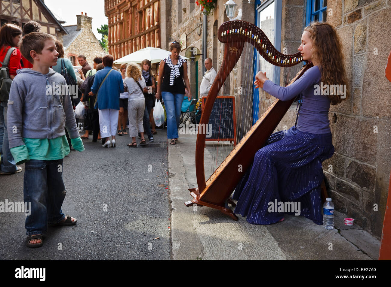 Harpist busking on market day, Tréguier, Côte d’Armor, Brittany, France Stock Photo