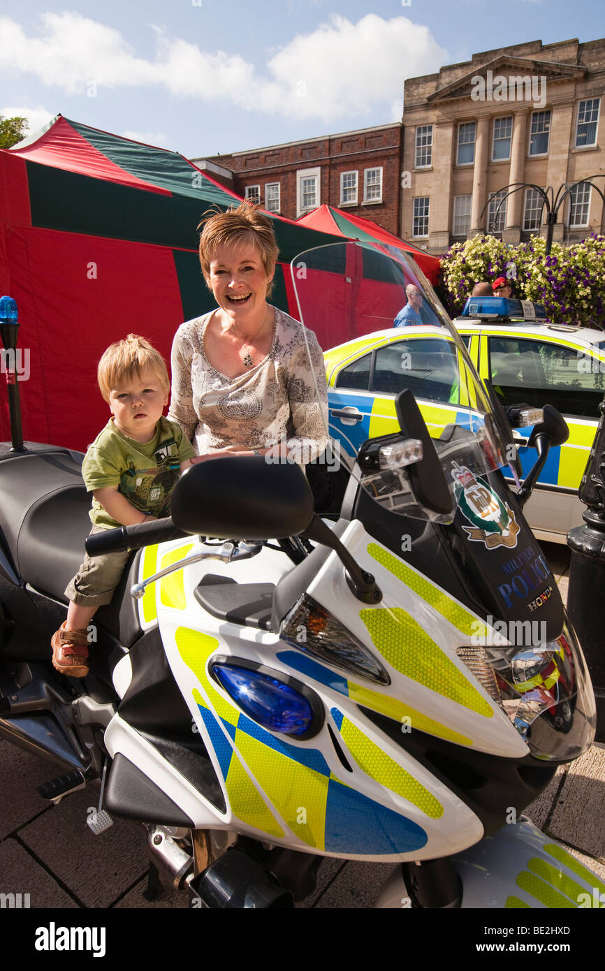 UK, England, Staffordshire, Stafford, Market Square, boy sat on Royal Military Police motorcycle with mother Stock Photo