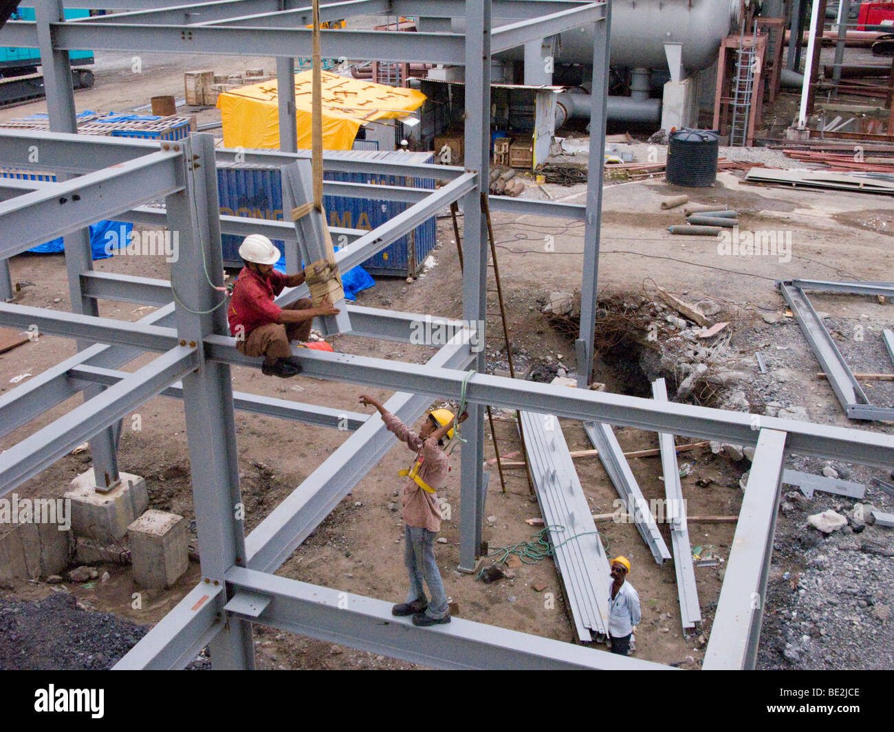 Indian construction workers assembling a factory building in an