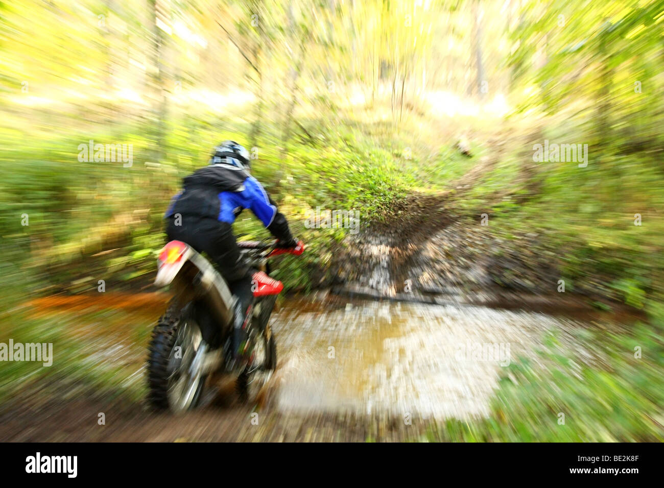 Offroad motorbike crossing river, water splashing around. Dynamic