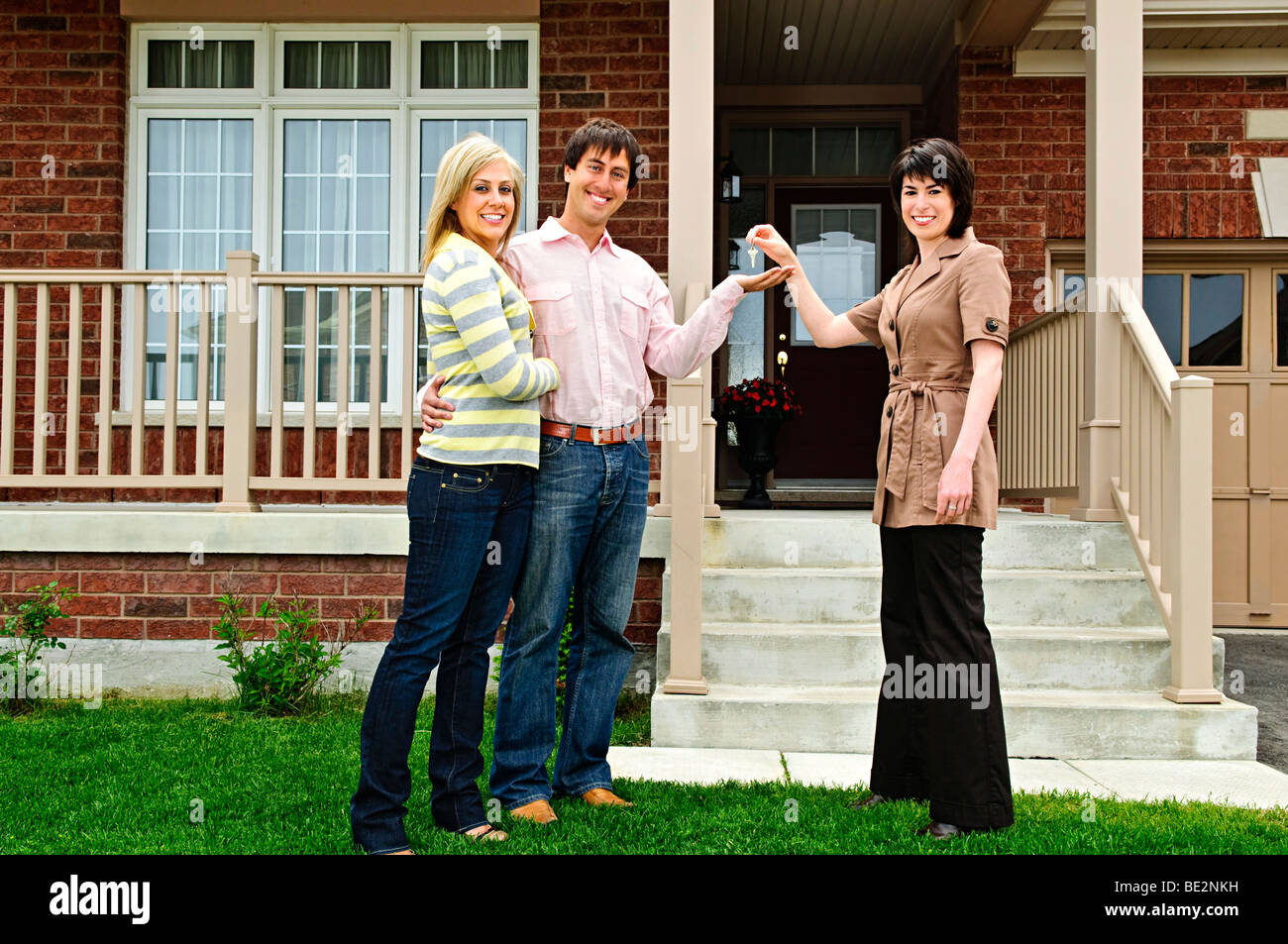 Happy couple getting keys to new house from real estate agent Stock ...