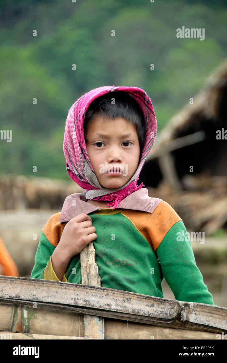 Poverty, portrait, girl of the Akha Pixor ethnic group with a headscarf looking sad, village Ban Moxoxang, Phongsali district,  Stock Photo