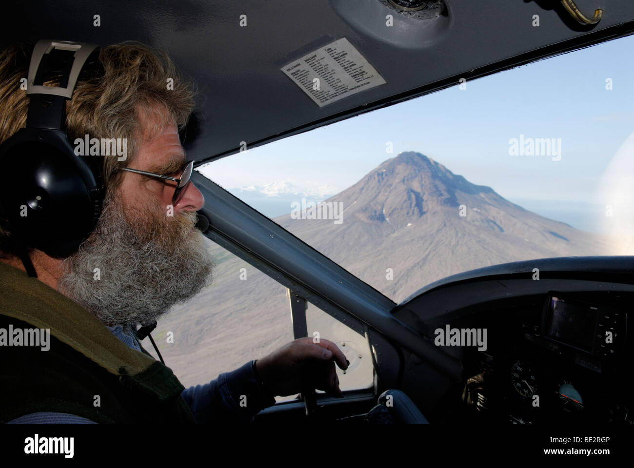 Alaskan bush pilot flying past Augustine Volcano Stock Photo