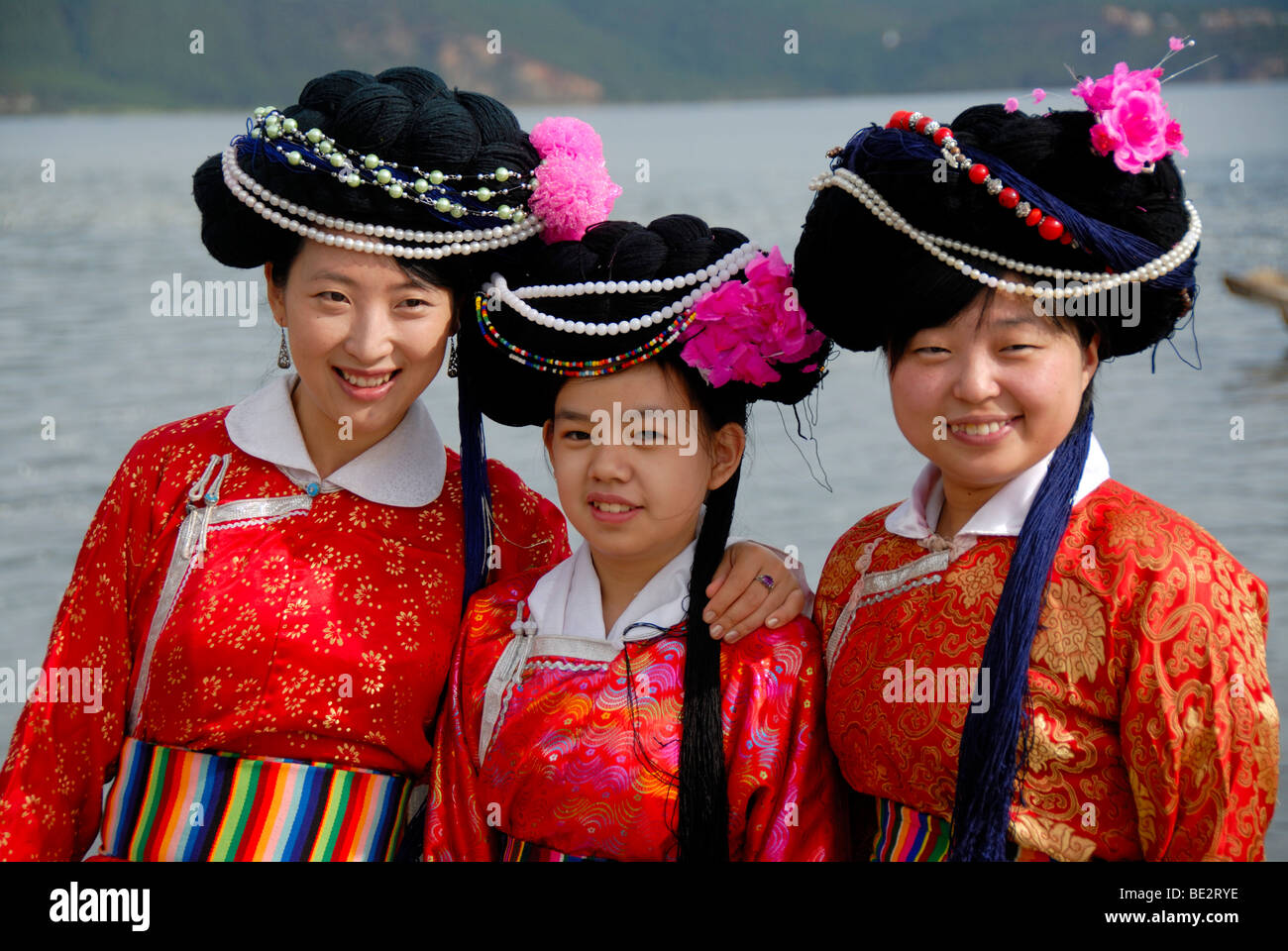 Ethnology, tourism, Chinese tourists, Han Chinese women dress in local garb for a photo, Luoshui, Lugu Hu Lake, Yunnan Province Stock Photo